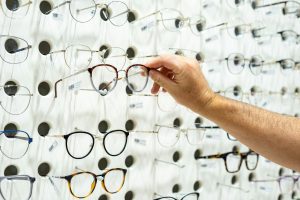 Person's hand picking the right glasses in the eyewear shop
